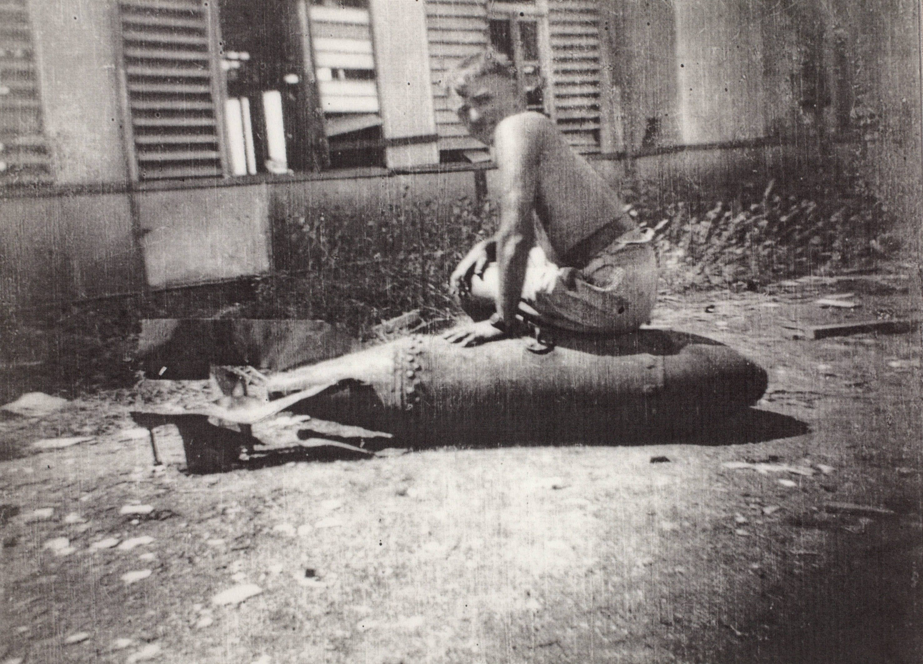 George A. Marven astride a defused unexploded 250 pound Japanese bomb